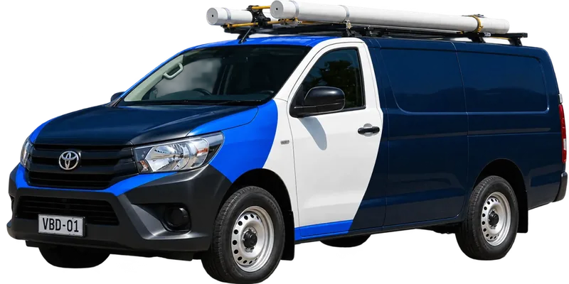 A licensed Penrith plumbing van loaded with pipe on the roof rack